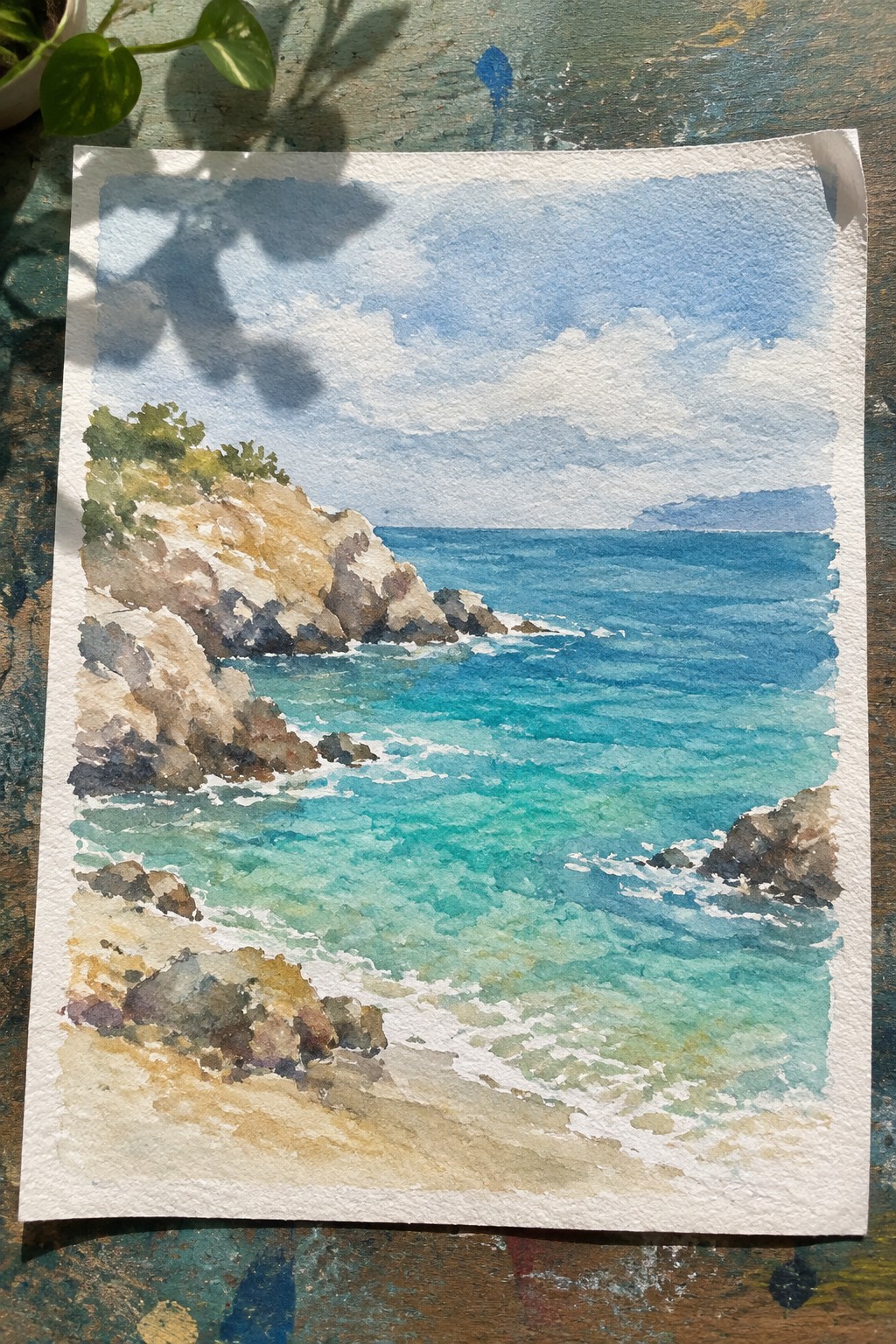 Watercolor of rocky cliffs, turquoise waves, and sandy shore under cloudy skies