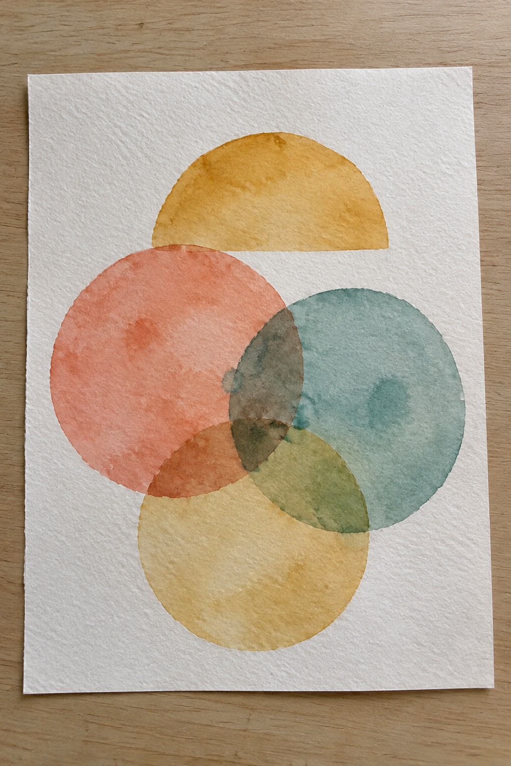 Abstract watercolor with overlapping coral, yellow, teal, and green circles on paper