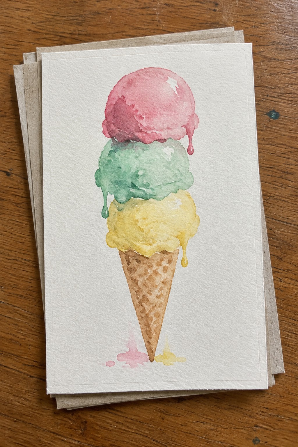 Watercolor of melting pink, green, and yellow three-scoop ice cream cone on paper