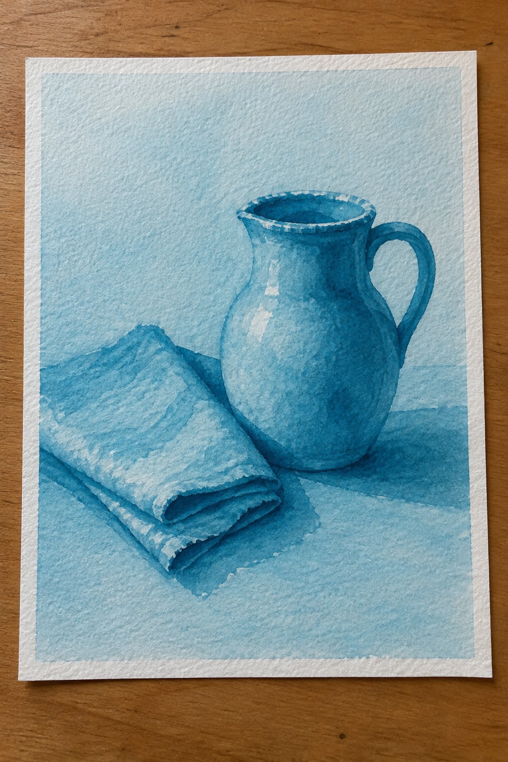 Blue watercolor still life of pitcher beside folded cloth on surface.