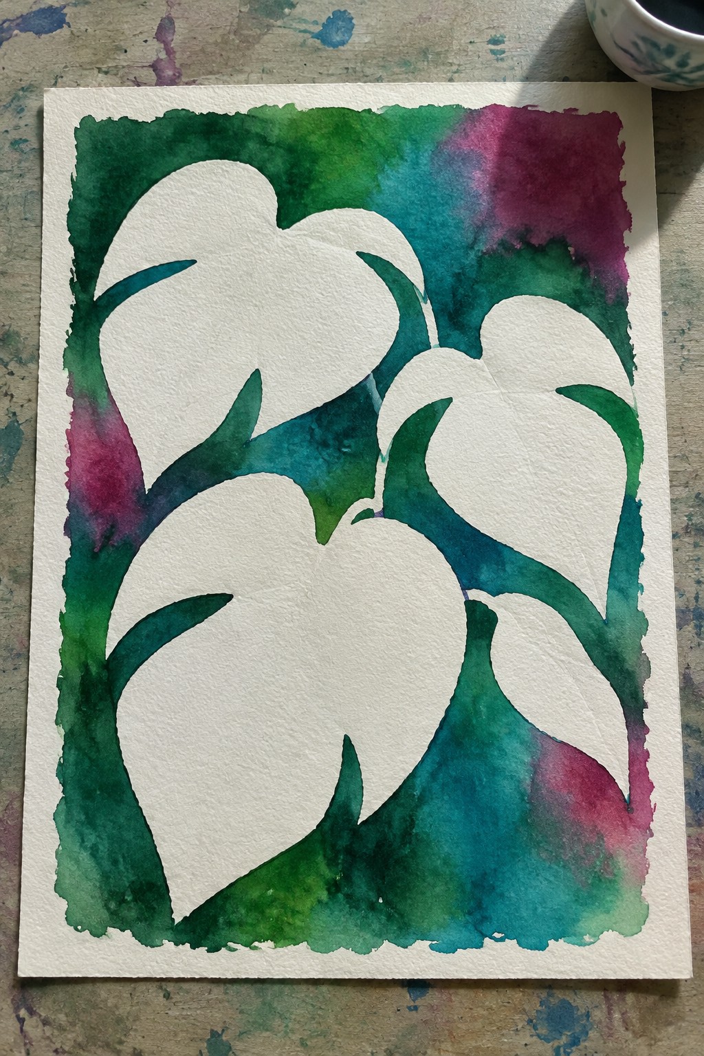 Watercolor painting of white leaf silhouettes on green, teal and magenta background