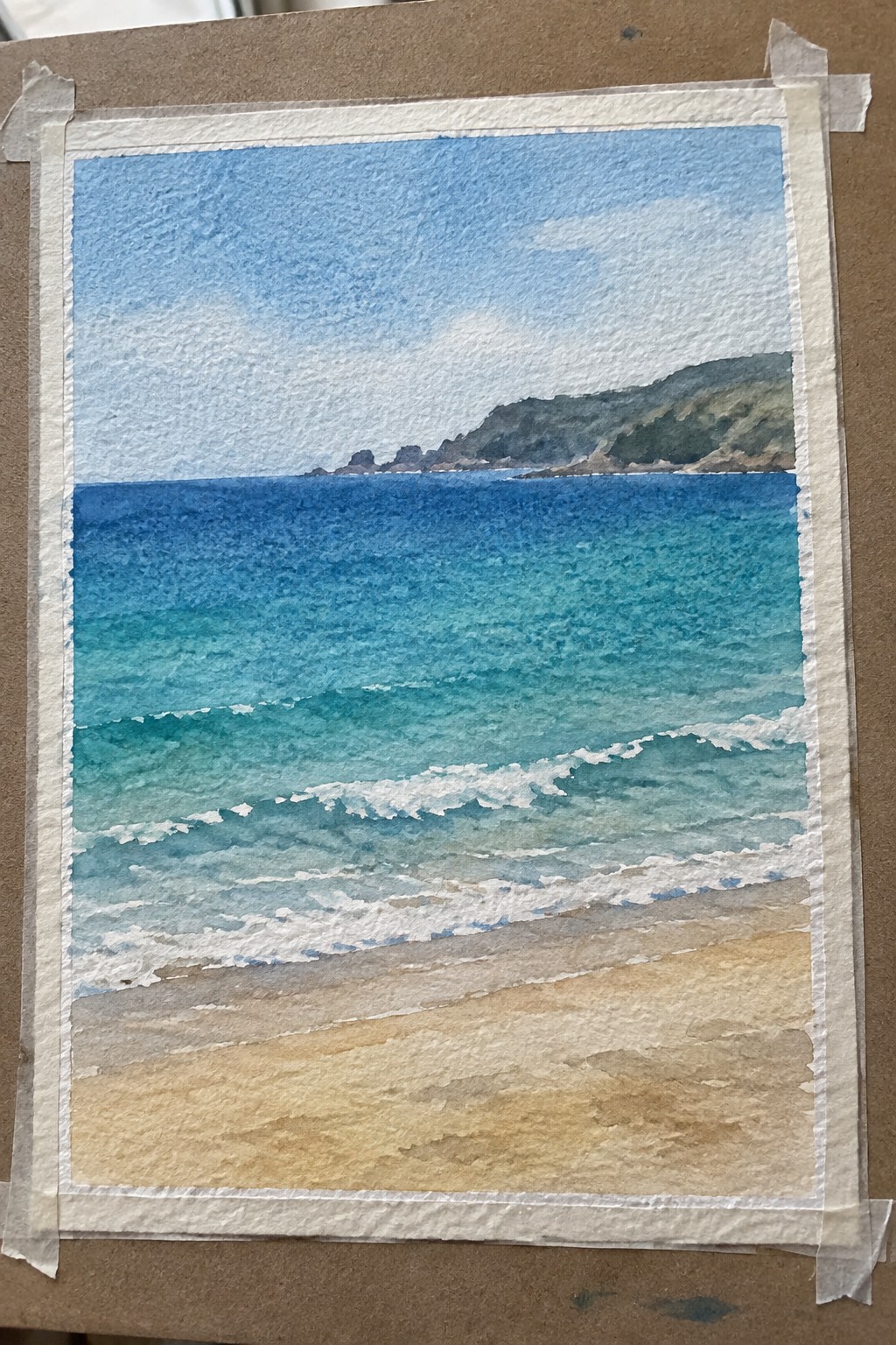 Watercolor seascape of turquoise waves with white foam on sandy beach, distant green hills under blue sky