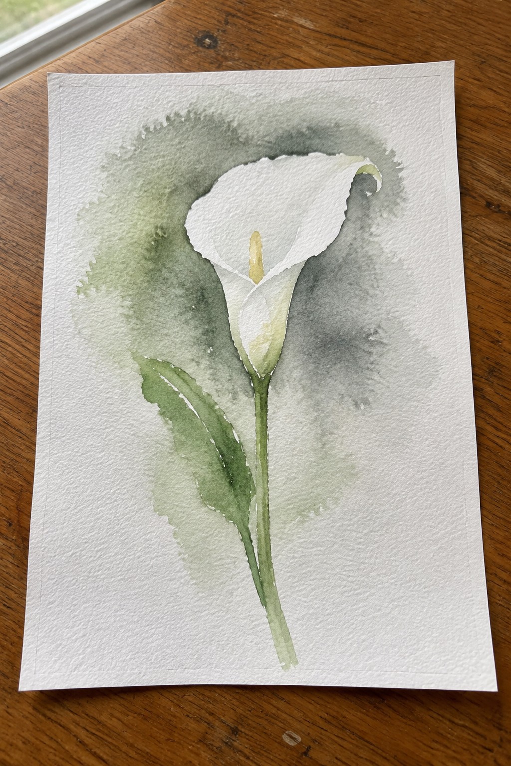 Watercolor of white calla lily with green stem, leaves, and soft gray-green washes