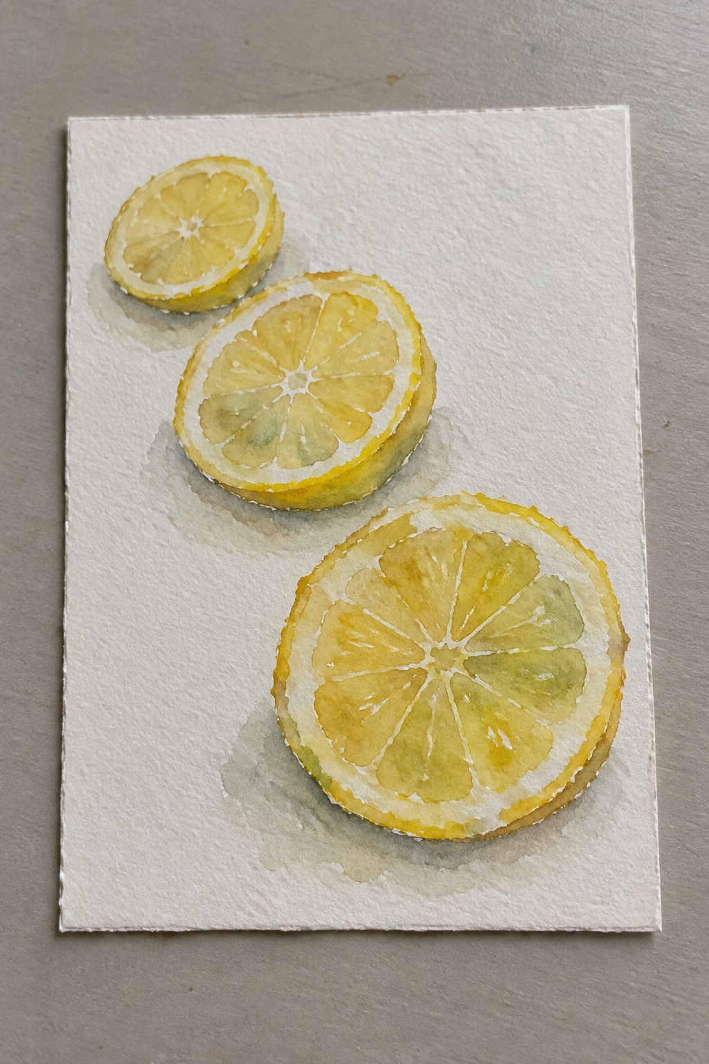 Three lemon slices in soft yellow-green watercolor washes on white paper.