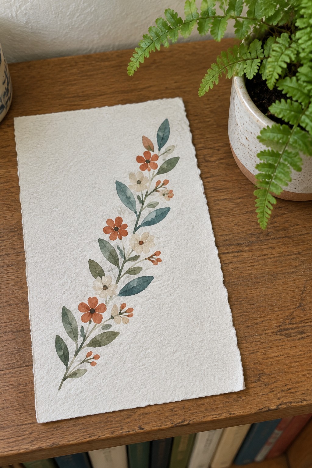Watercolor floral vine with orange flowers, white blooms, and green leaves on textured paper