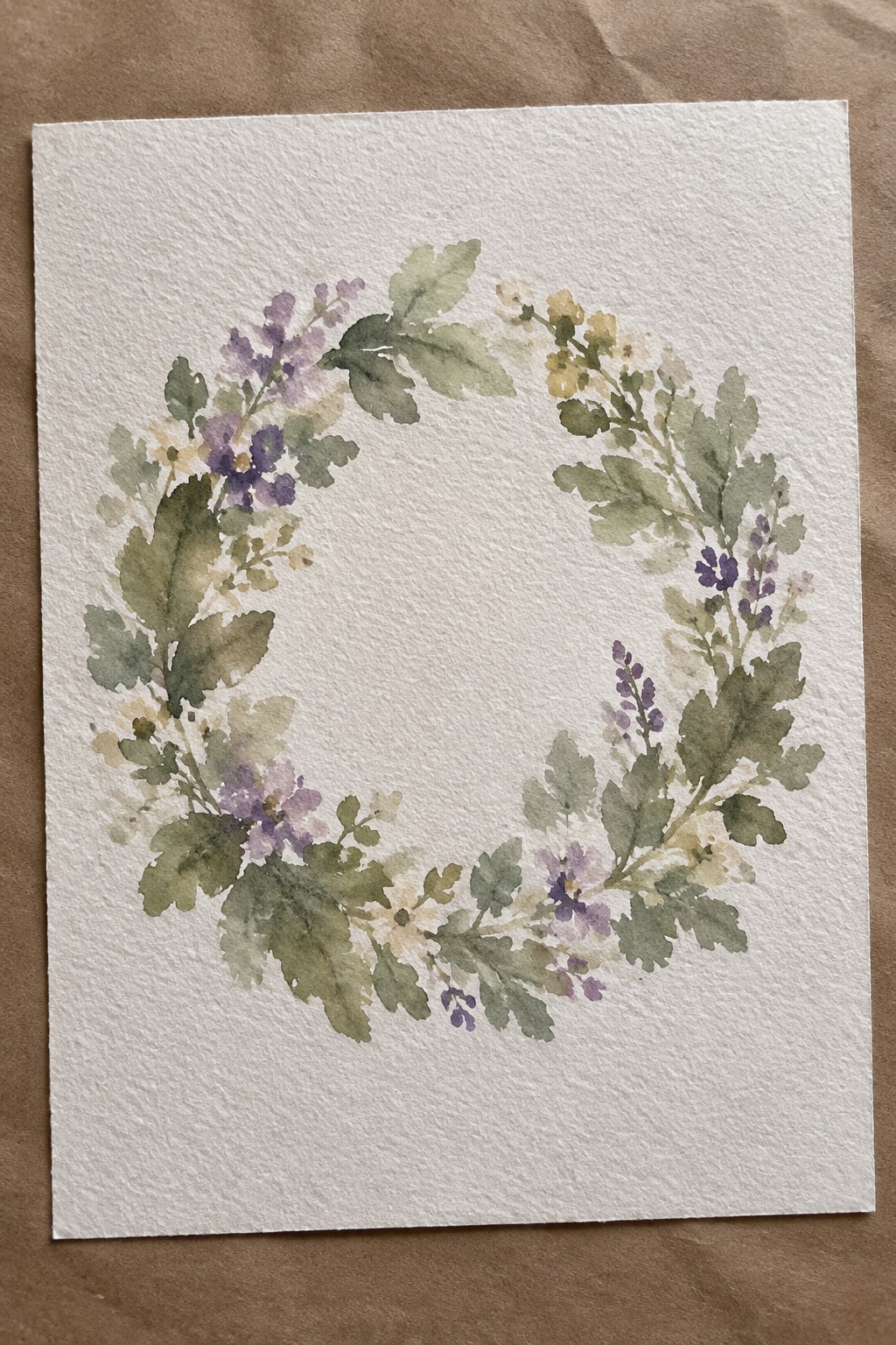 Watercolor wreath of purple flowers and green leaves on textured white paper