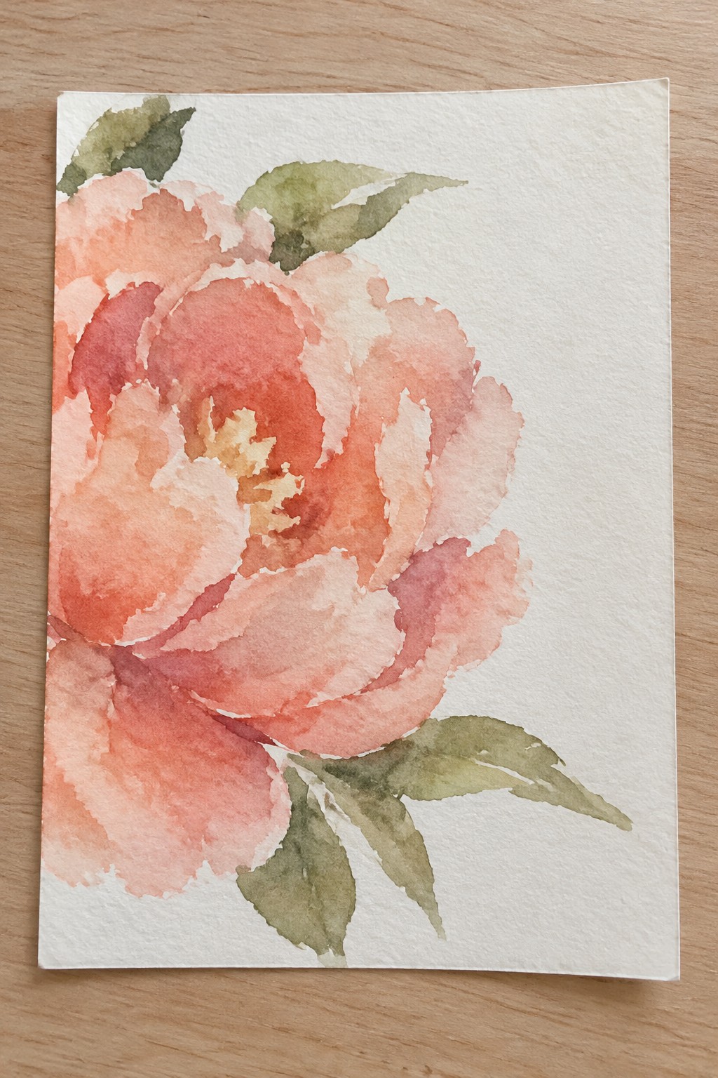 Watercolor painting of a blooming coral peony with soft pink tones and green leaves on white paper