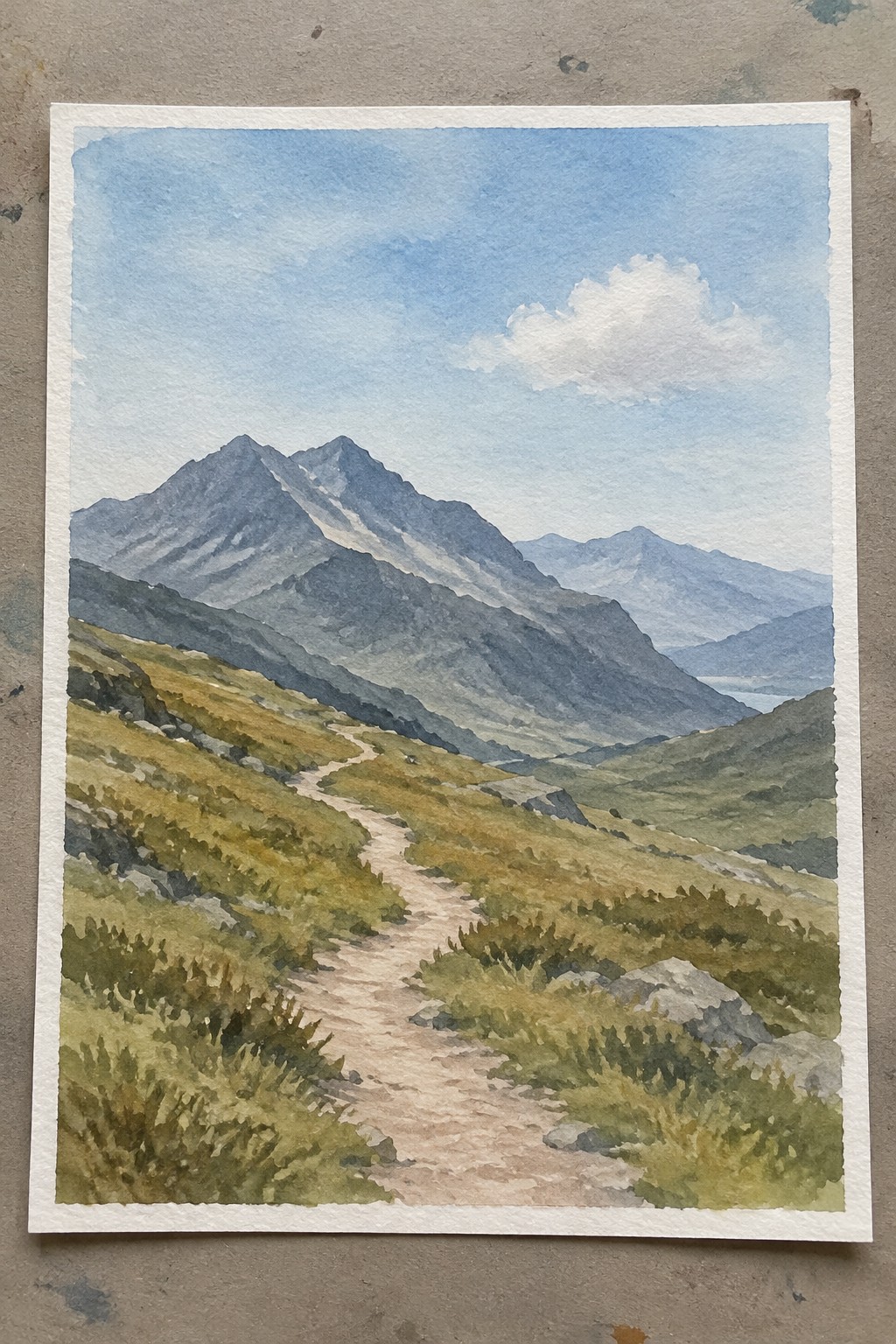 Winding path through grassy hills toward rocky blue mountains under cloudy sky in watercolor.