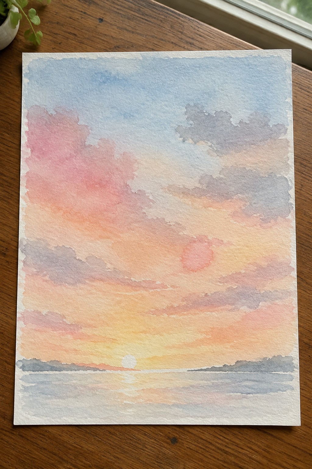 Watercolor sunset with pink-orange clouds over calm water and horizon.
