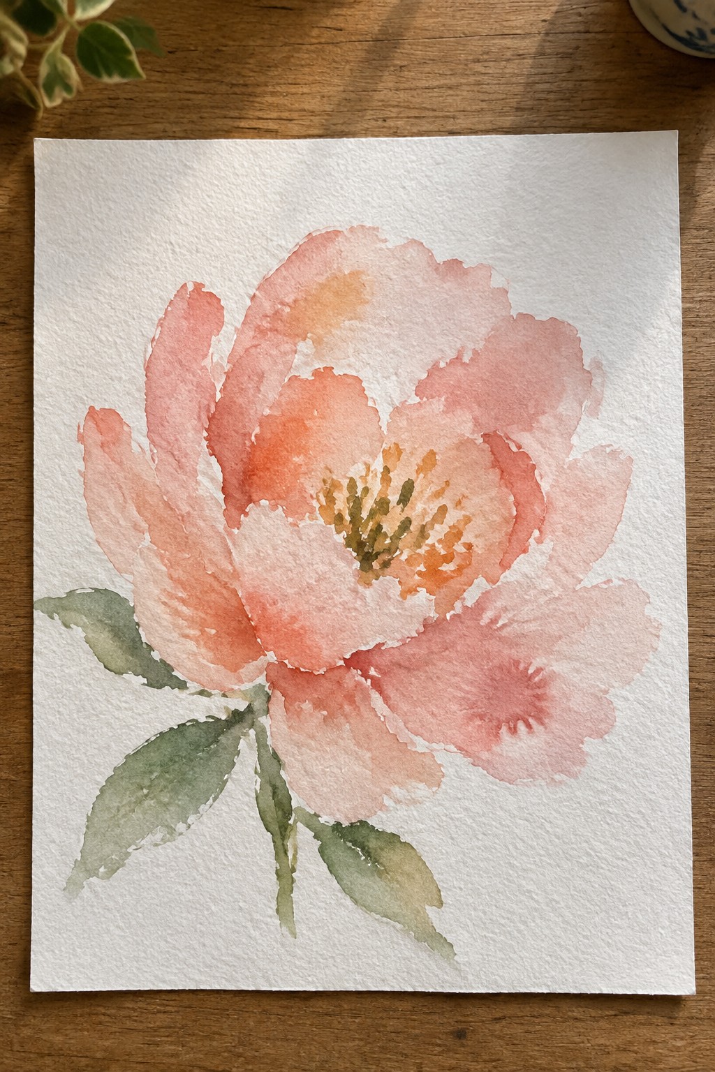 Watercolor painting of a coral pink peony with green leaves on paper