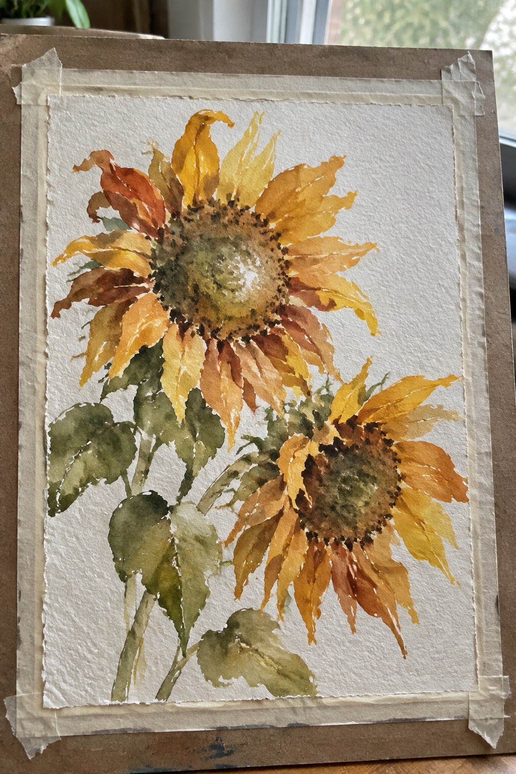 Watercolor painting of two sunflowers with yellow-orange petals, brown centers, and green leaves.