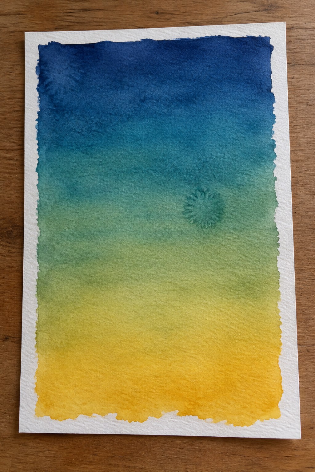 A vertical watercolor gradient on deckled white paper transitions from dark blue at the top through teal and green to yellow at the bottom, with a small green circular motif in the middle right area.