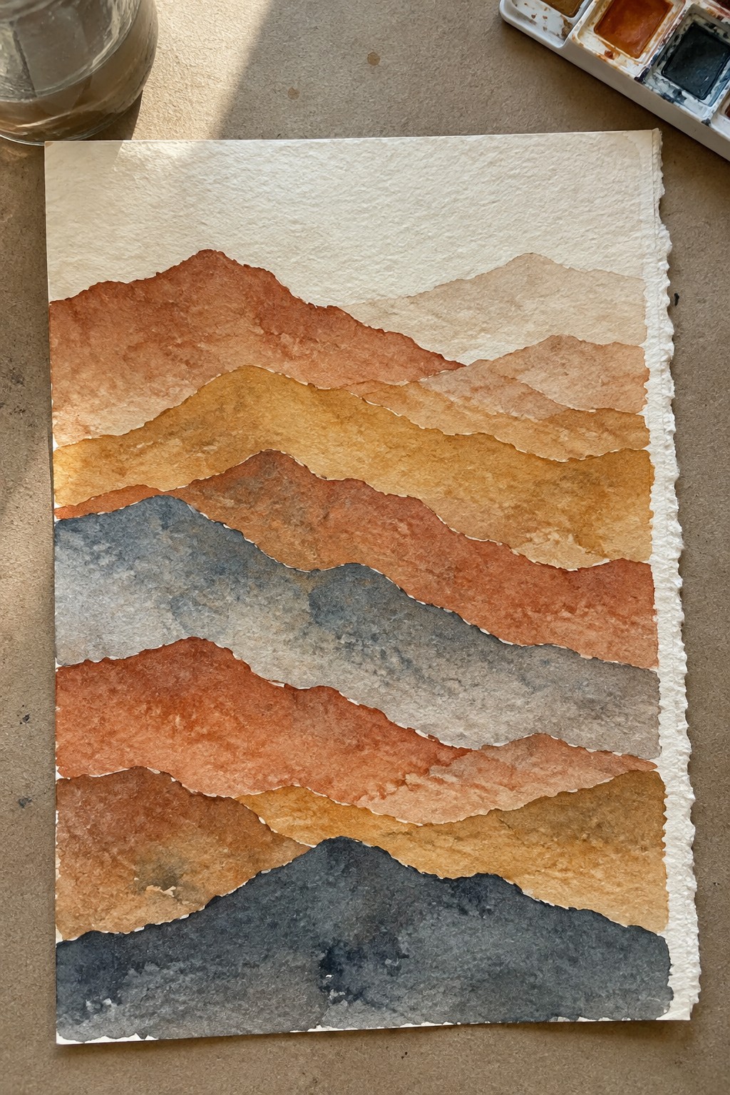 Layered mountain ranges in warm orange, brown, and gray watercolor washes on white paper